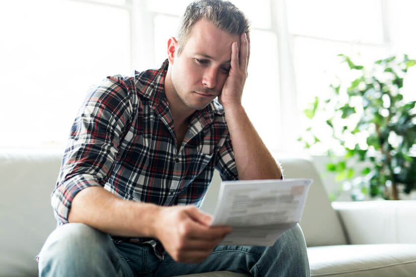 man reading solicitor letter chasing debt repayments 